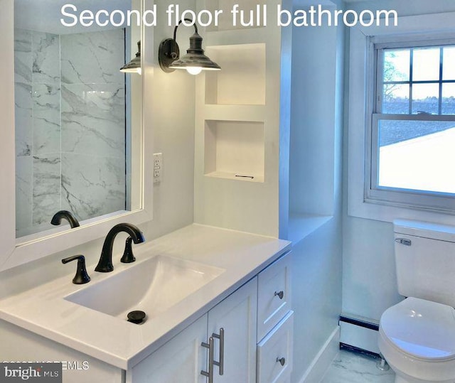 bathroom with toilet, a wealth of natural light, a baseboard heating unit, and vanity