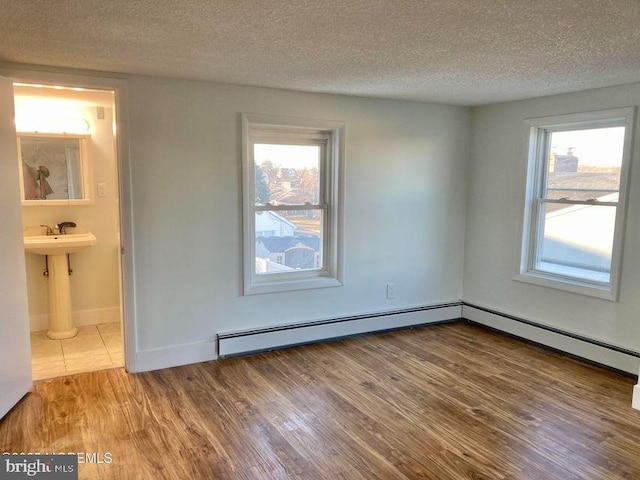 empty room with wood-type flooring and a textured ceiling