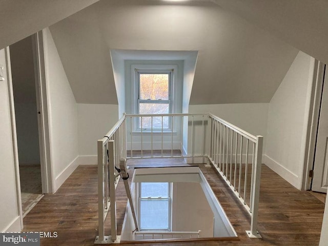 stairs with vaulted ceiling and hardwood / wood-style floors