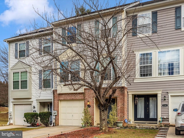 multi unit property featuring concrete driveway, brick siding, and an attached garage