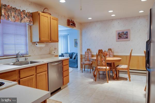 kitchen featuring stainless steel appliances, a baseboard radiator, and sink