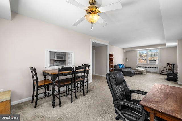 home office with baseboards, radiator, a ceiling fan, and carpet