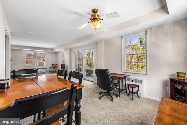 carpeted office space featuring cooling unit, radiator, and ceiling fan