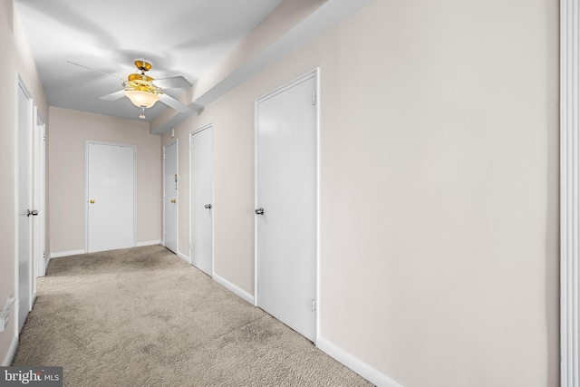 corridor with baseboards and carpet floors