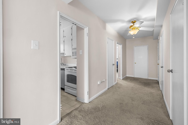 corridor with light colored carpet and baseboards