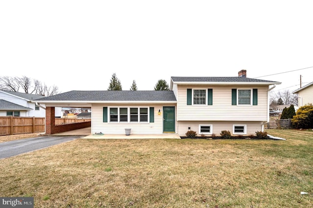 split level home featuring a front lawn and a carport