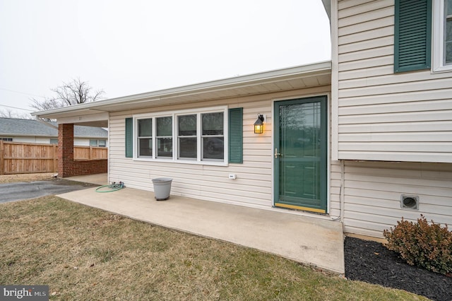 doorway to property with a patio area and a lawn