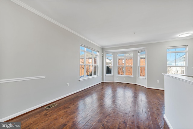 unfurnished room with dark wood-style floors, a wealth of natural light, visible vents, and baseboards