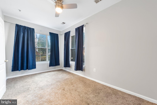 empty room featuring carpet, visible vents, and baseboards