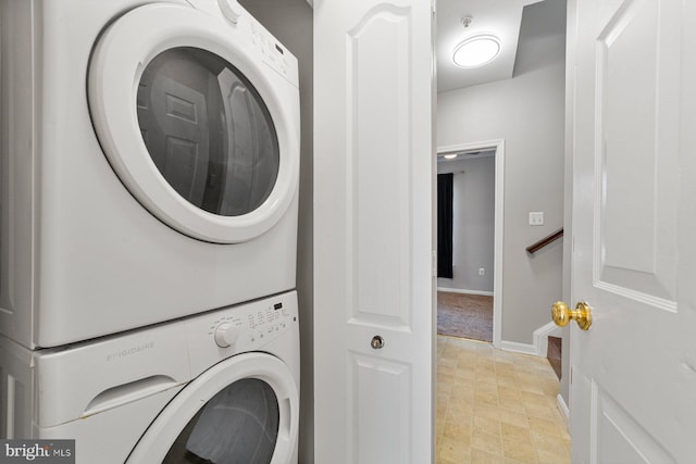 laundry room with laundry area, baseboards, and stacked washer / drying machine