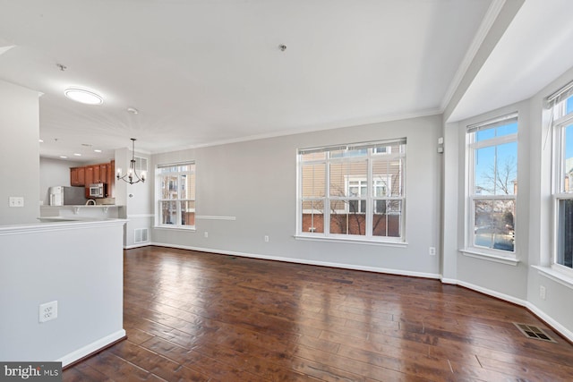 unfurnished living room with plenty of natural light, dark wood-style floors, baseboards, and visible vents