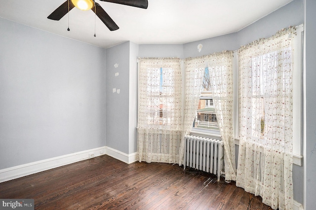 unfurnished room featuring radiator, ceiling fan, and dark hardwood / wood-style floors