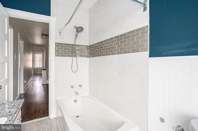 bathroom with wood-type flooring and tiled shower / bath