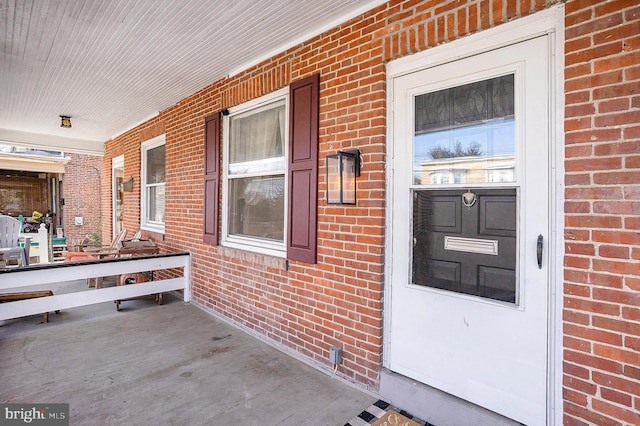 view of exterior entry featuring covered porch