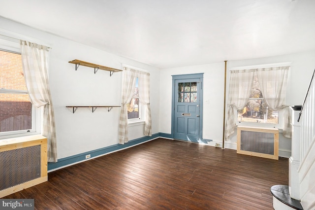 entrance foyer with radiator heating unit and dark hardwood / wood-style floors