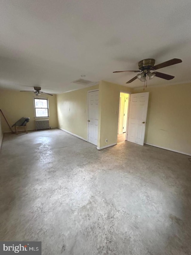 unfurnished room with radiator heating unit, concrete floors, and ceiling fan