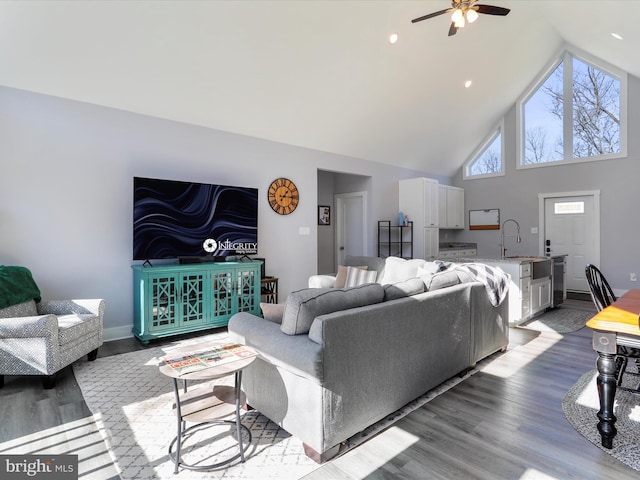 living room featuring hardwood / wood-style flooring, high vaulted ceiling, sink, and ceiling fan