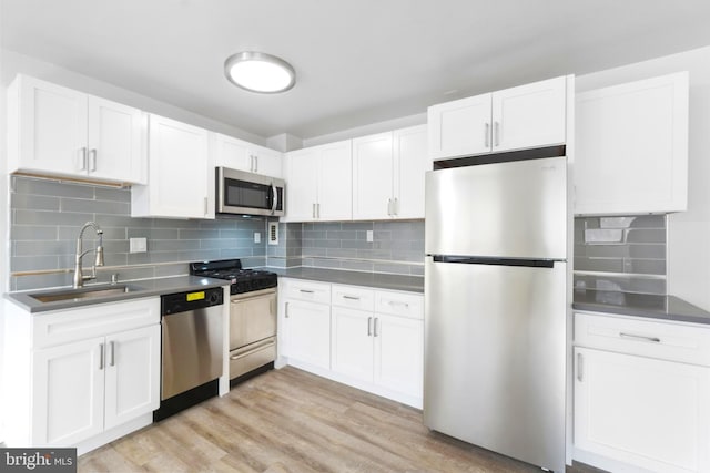 kitchen with white cabinetry, stainless steel appliances, light hardwood / wood-style flooring, and sink