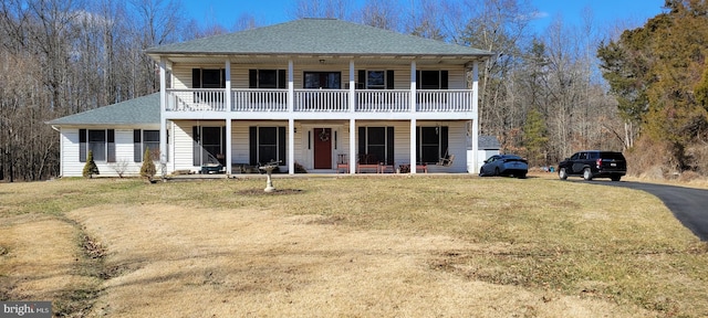 back of property featuring a porch, a lawn, and a shingled roof