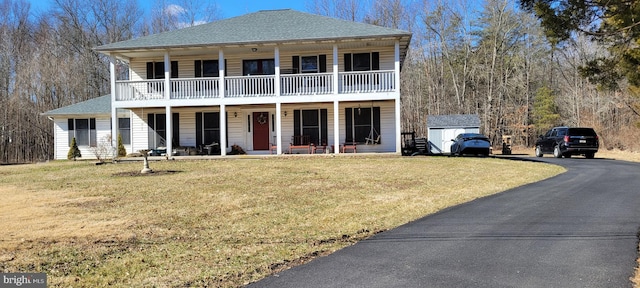 view of front of house with driveway, a porch, a front yard, and a balcony