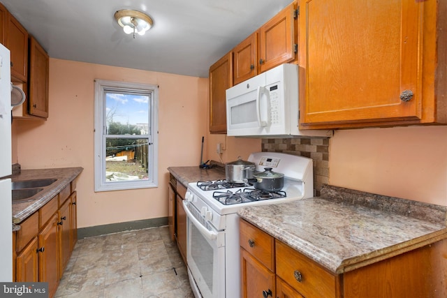 kitchen featuring sink, backsplash, and white appliances