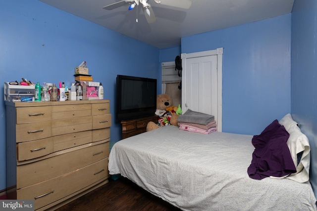 bedroom featuring ceiling fan, a closet, and dark wood-type flooring