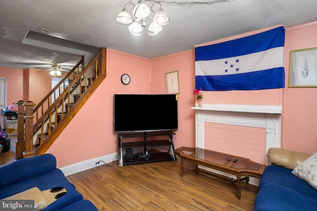 living room featuring ceiling fan with notable chandelier, crown molding, and wood-type flooring