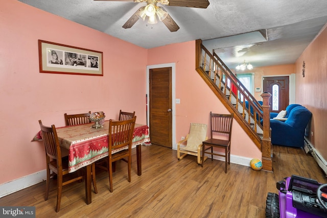 dining room featuring a textured ceiling, hardwood / wood-style floors, ceiling fan, and a baseboard heating unit