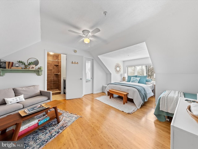 bedroom with light wood finished floors, a ceiling fan, vaulted ceiling, and a textured ceiling