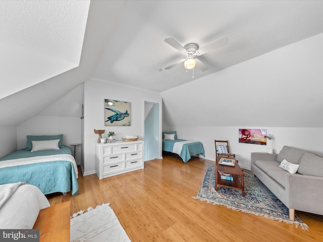 bedroom with lofted ceiling, light wood-style flooring, and a ceiling fan