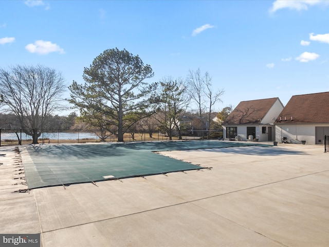 community pool with fence and a patio