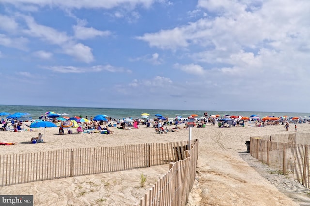 view of water feature with fence and a beach view