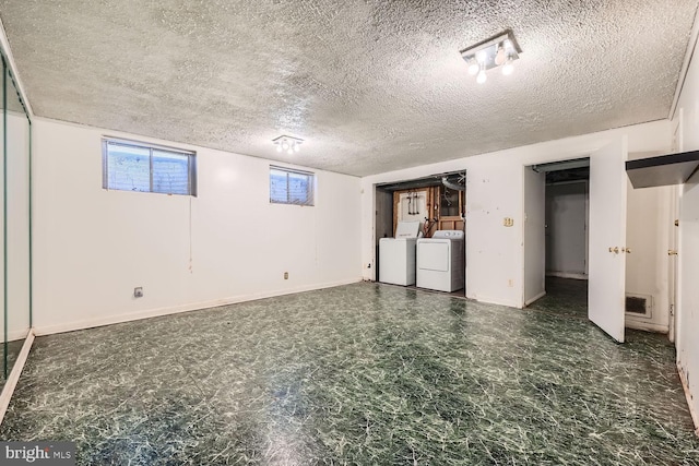 basement with washer and dryer and a textured ceiling