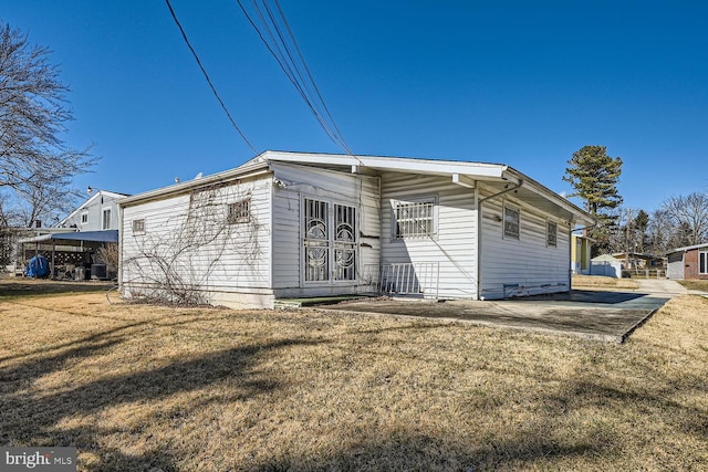 view of front of property with a carport and a front lawn