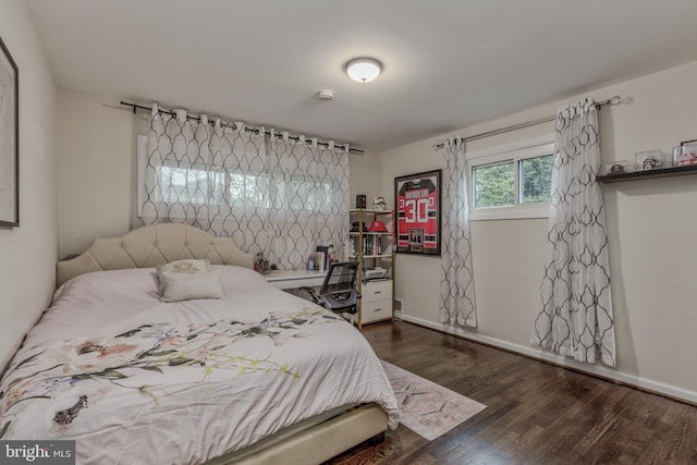 bedroom with dark wood-type flooring and baseboards