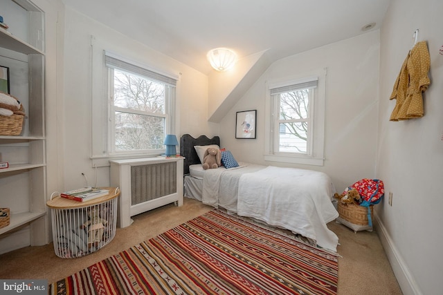 bedroom featuring baseboards, light carpet, and radiator