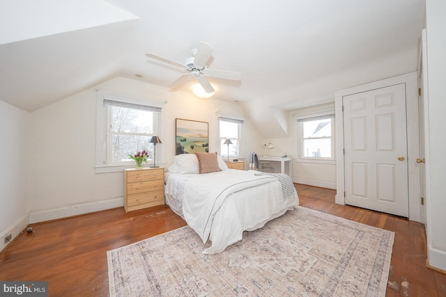 bedroom with ceiling fan, vaulted ceiling, baseboards, and wood finished floors