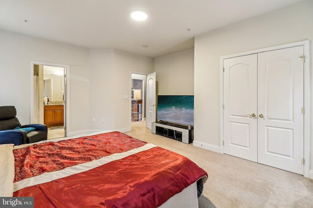 bedroom with recessed lighting, a closet, light carpet, connected bathroom, and baseboards