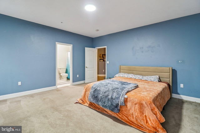 bedroom with carpet flooring, connected bathroom, and baseboards