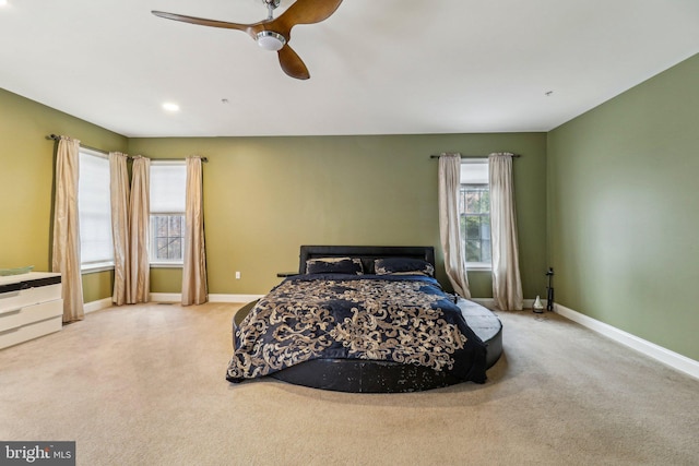 bedroom featuring light carpet, baseboards, and a ceiling fan