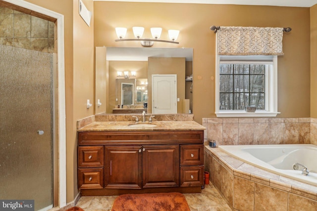 full bathroom with a stall shower, vanity, and a bath