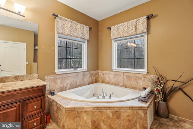 bathroom with a garden tub, plenty of natural light, and vanity