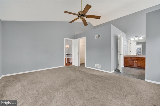 unfurnished bedroom featuring light carpet, visible vents, a walk in closet, and lofted ceiling