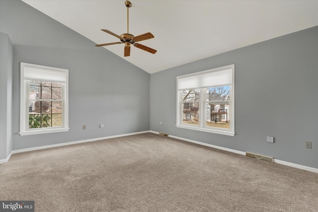 carpeted spare room featuring a ceiling fan, visible vents, vaulted ceiling, and baseboards