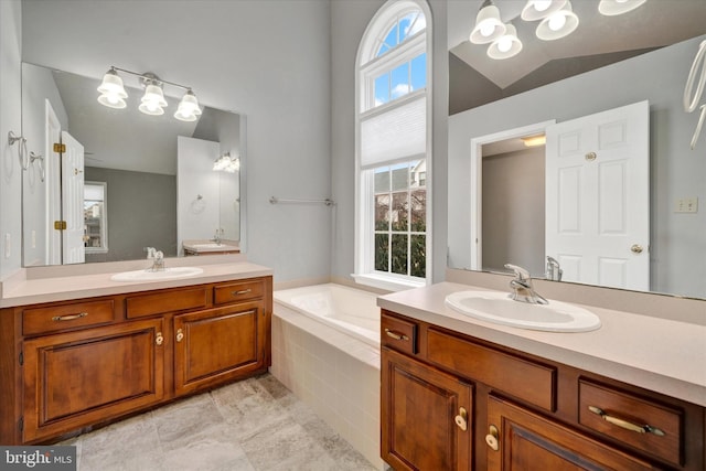 full bath featuring vaulted ceiling, two vanities, a sink, and a bath