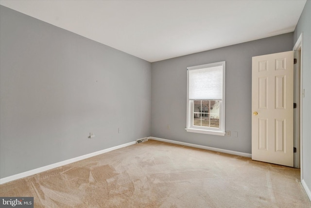 unfurnished room featuring light colored carpet, visible vents, and baseboards