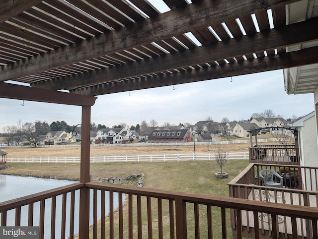 wooden deck with a residential view, a water view, a yard, and a pergola