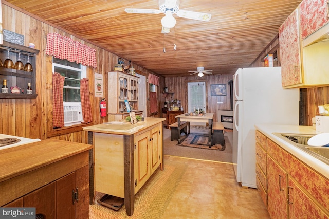 kitchen with white fridge, wood ceiling, wood walls, and a kitchen island