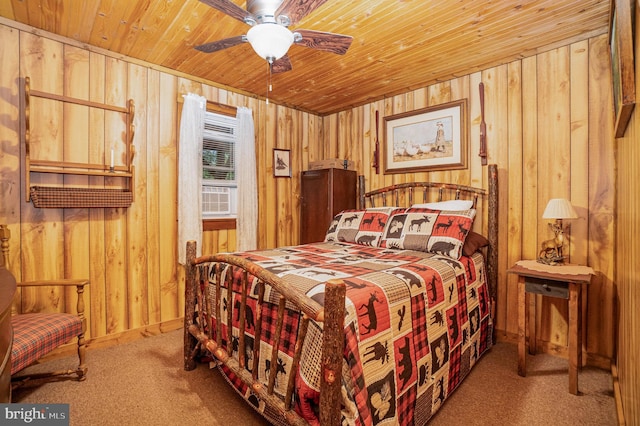 bedroom with ceiling fan, carpet flooring, wood ceiling, and wood walls