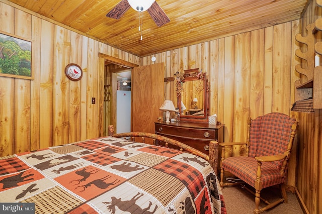 bedroom featuring ceiling fan, wood ceiling, carpet, and wood walls